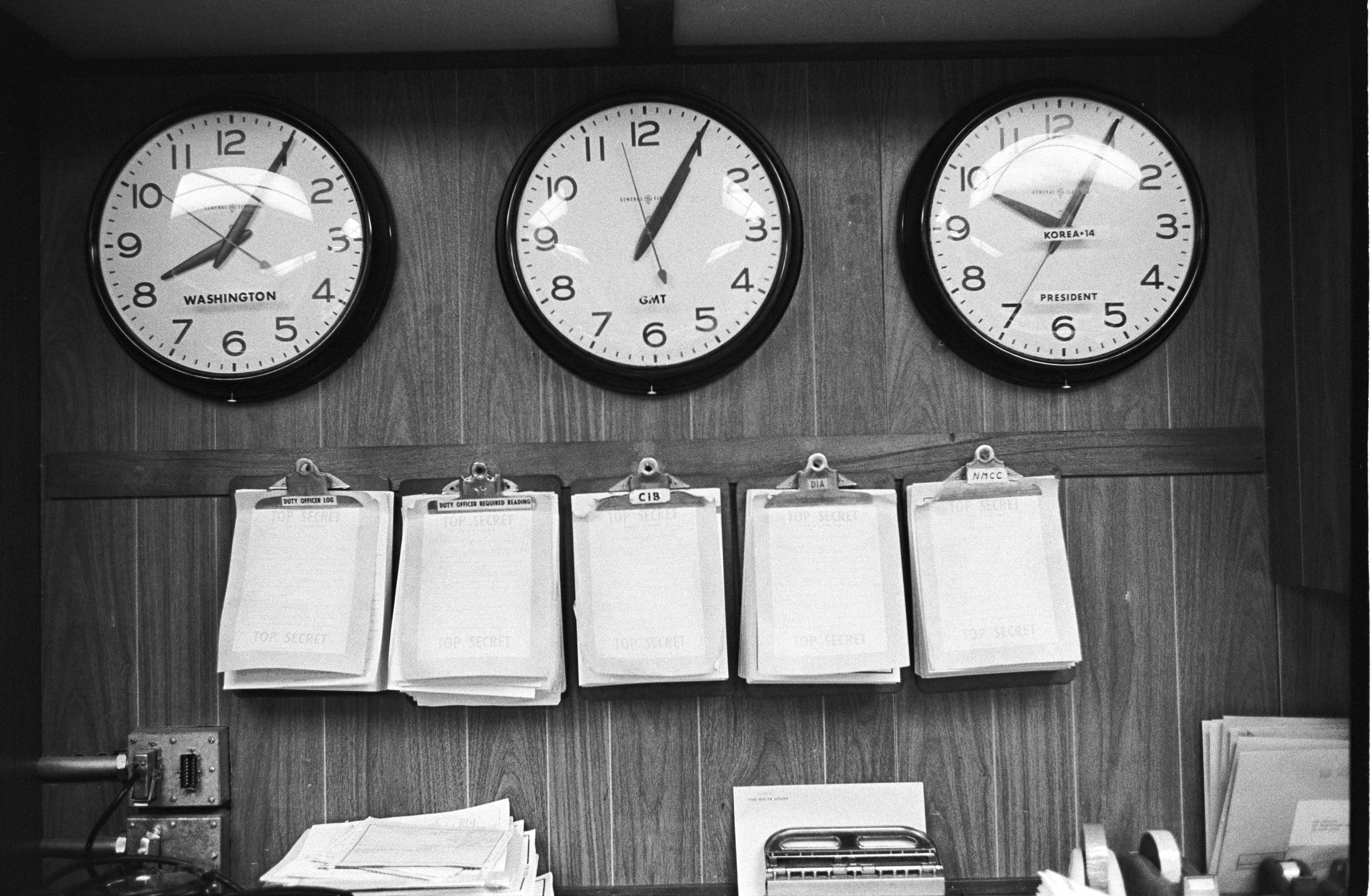 Three wall clocks labeled to depict times for Washington, GMT, and Korea+14; President. LBJ Library photo by Yoichi Okamoto #A5635-22.