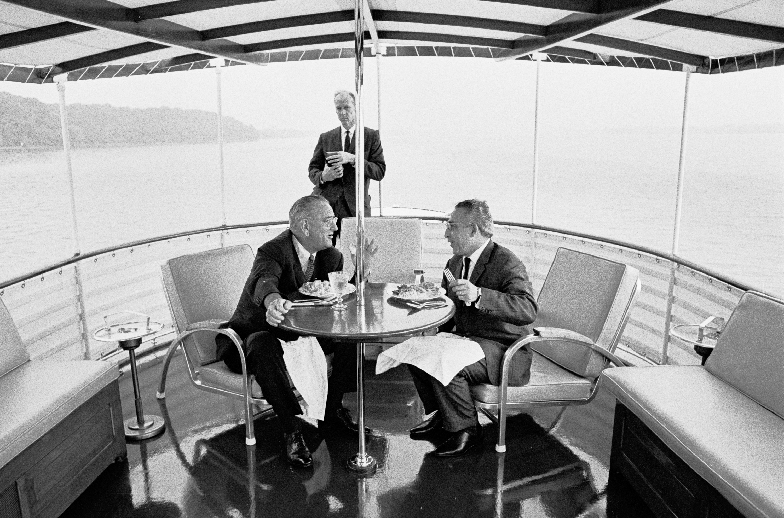 President Lyndon B. Johnson and unidentified dinner guest. USSS Agent Rufus Youngblood standing in background.