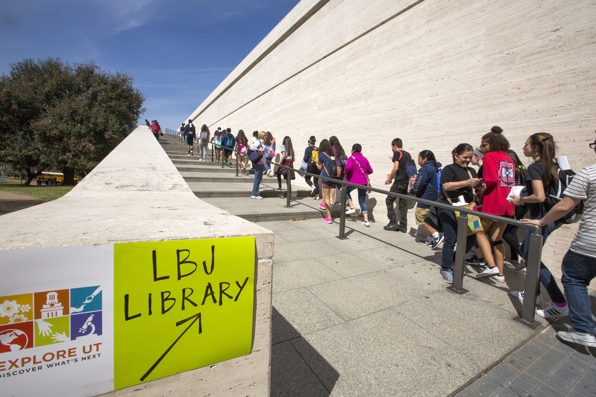 A line of students walks up stairs on their way to the LBJ Library.