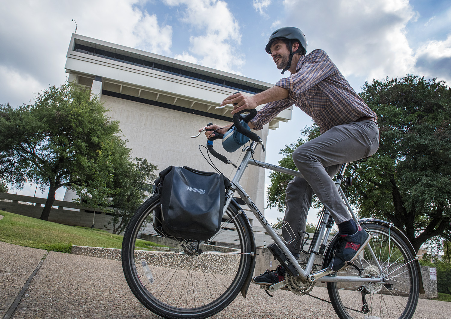 A cyclist bikes by the LBJ Library