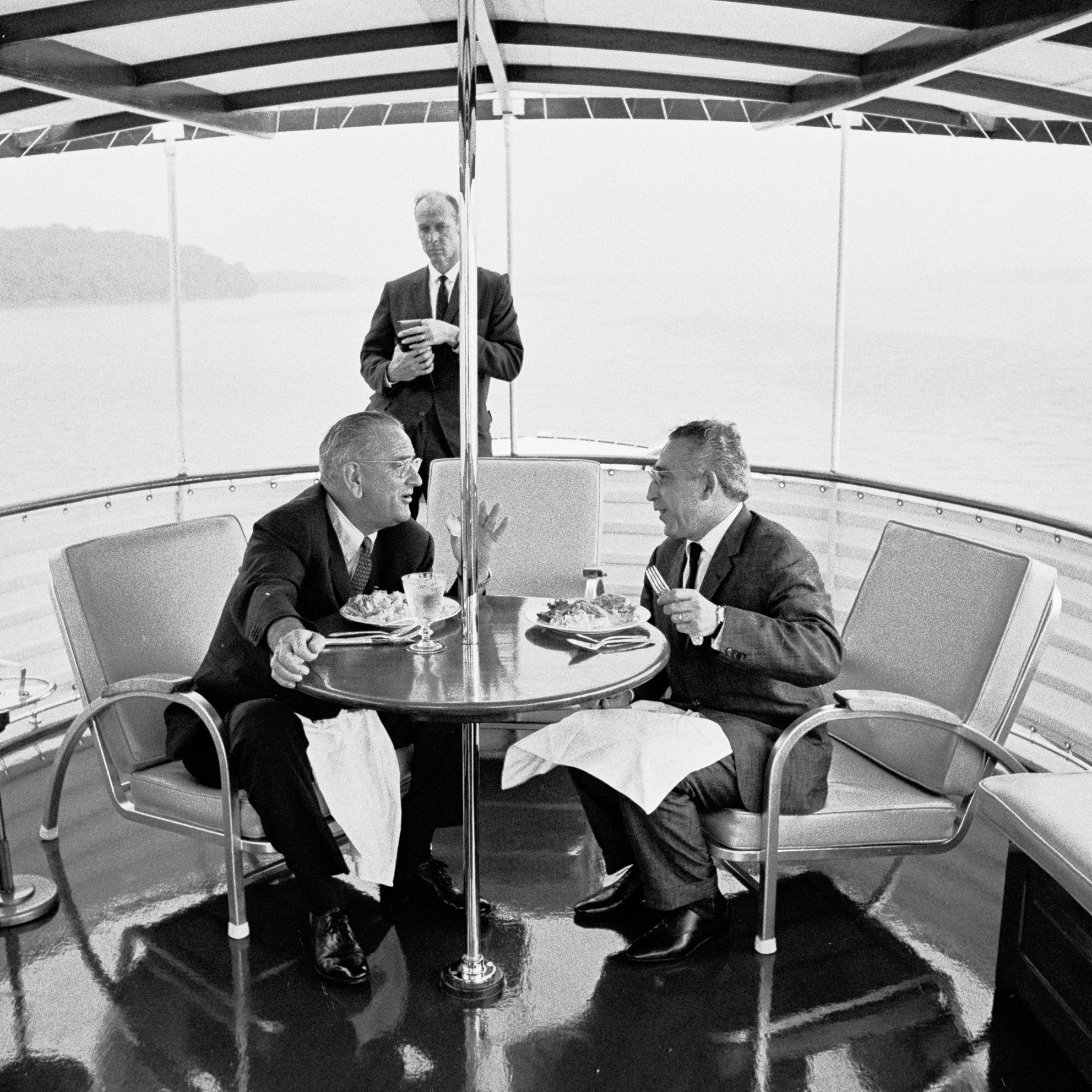 President Lyndon B. Johnson and unidentified dinner guest. USSS Agent Rufus Youngblood standing in background.