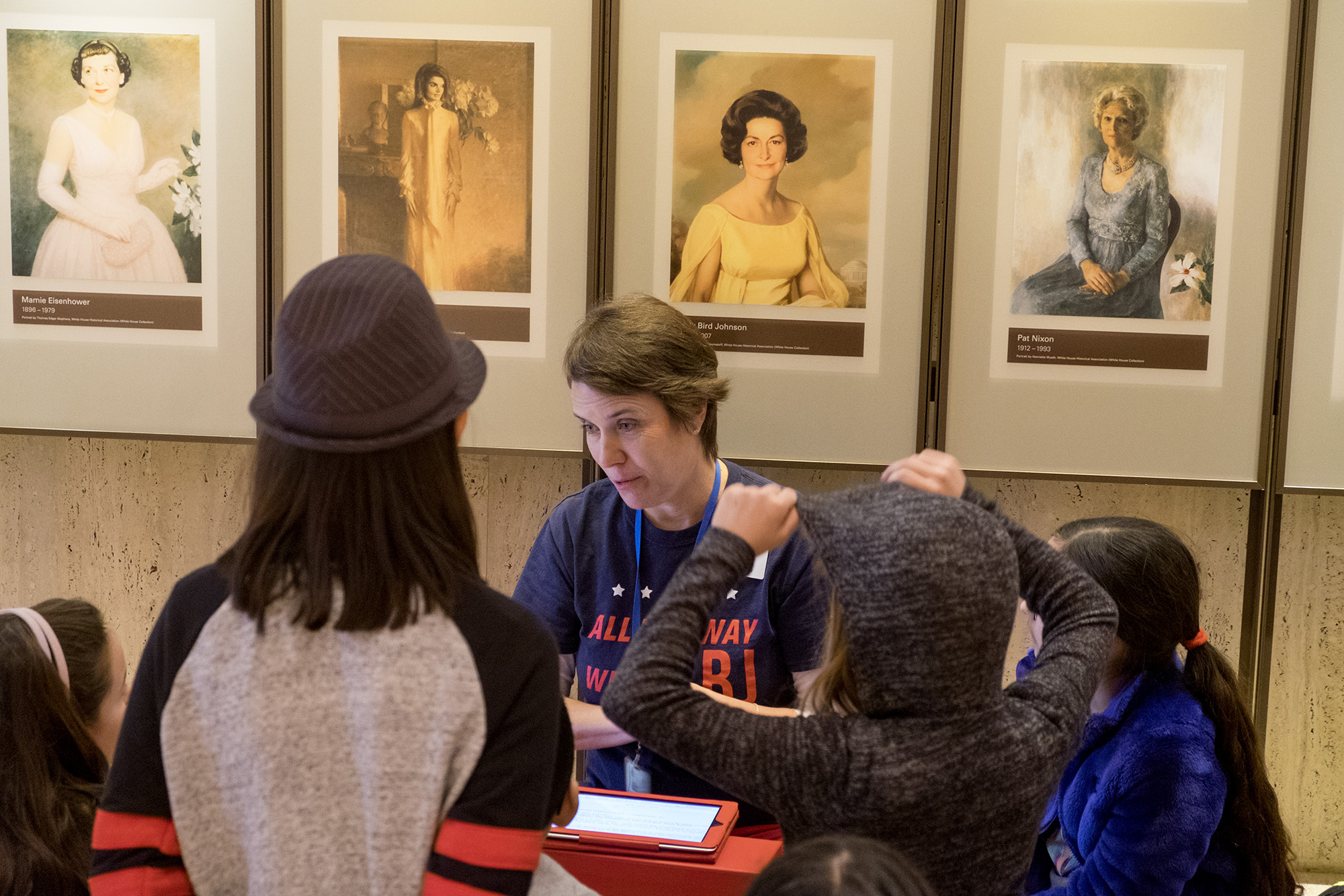 LBJ Library volunteer shows young visitors some of the things found in the Library archives.