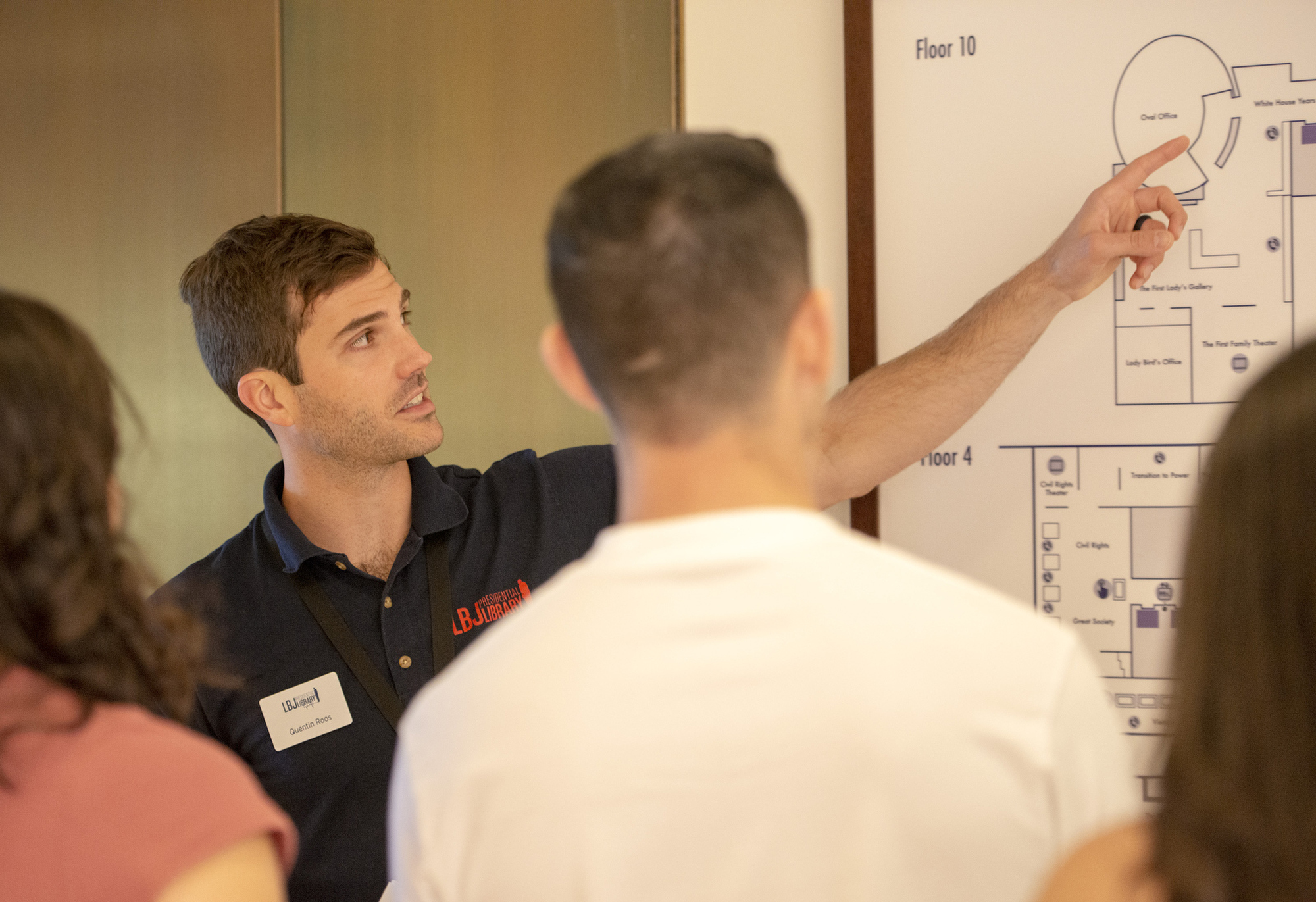 An LBJ Library volunteer gives visitors an orientation overview before they enter the exhibition spaces.