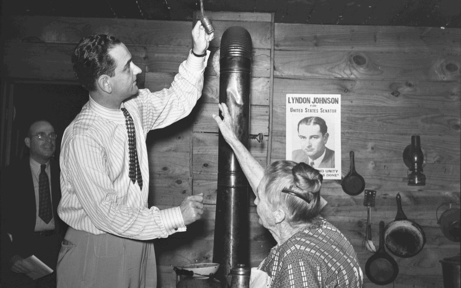Congressman Lyndon B. Johnson and Mrs. Mattie Malone examine an electric light fixture.