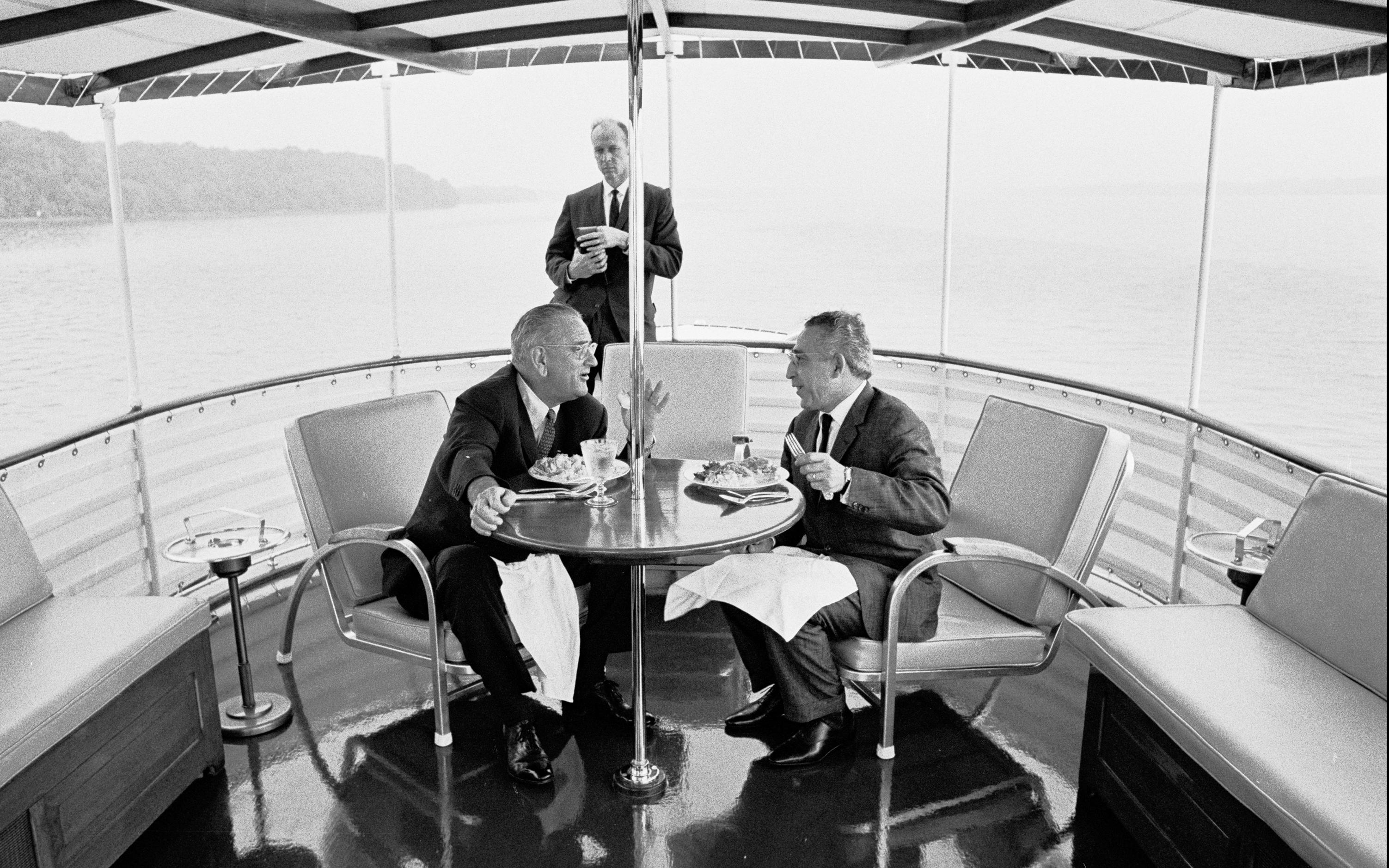 President Lyndon B. Johnson and unidentified dinner guest. USSS Agent Rufus Youngblood standing in background.