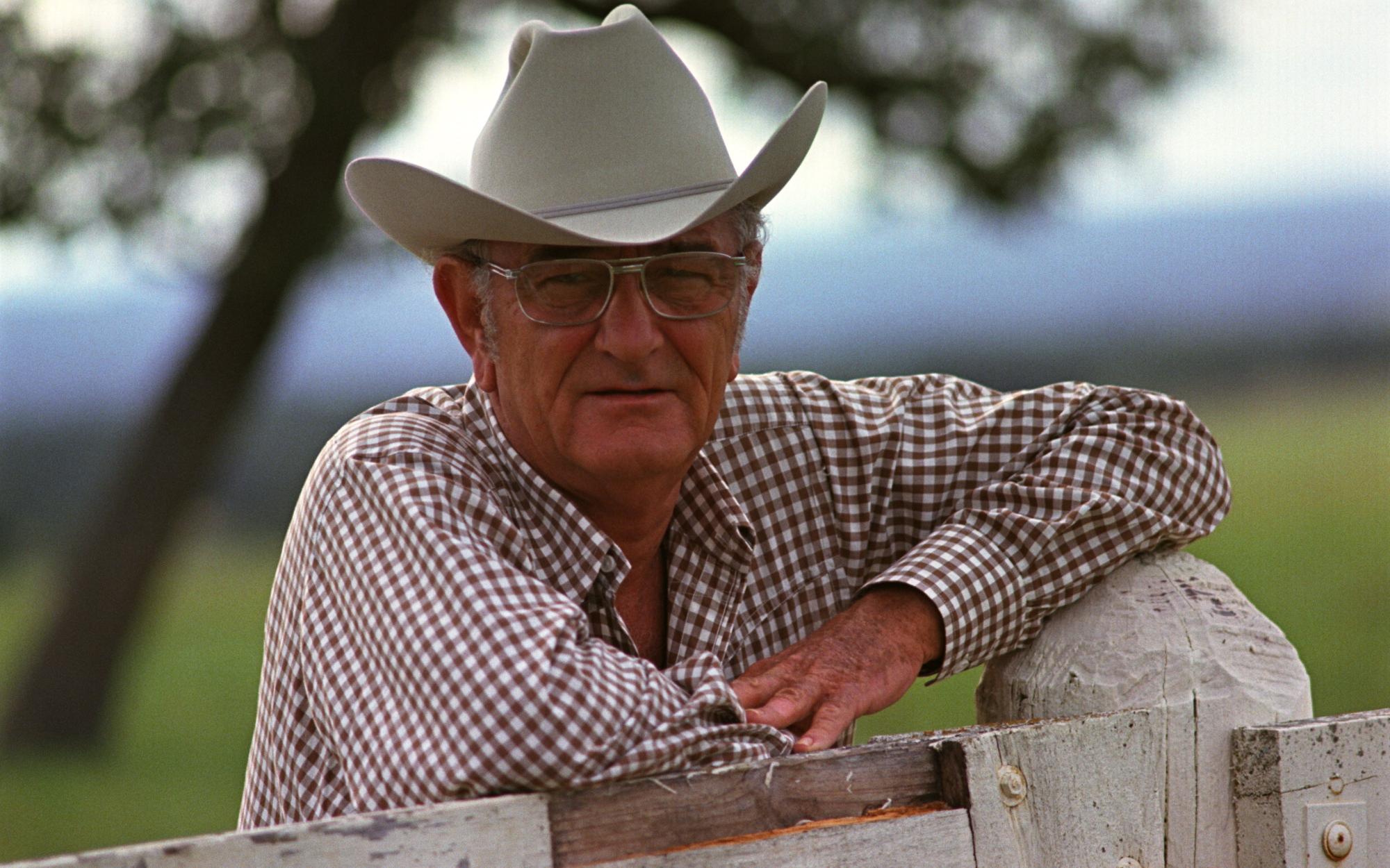 Portrait of Lyndon B. Johnson, with his arms resting on a fence, at the LBJ ranch.
