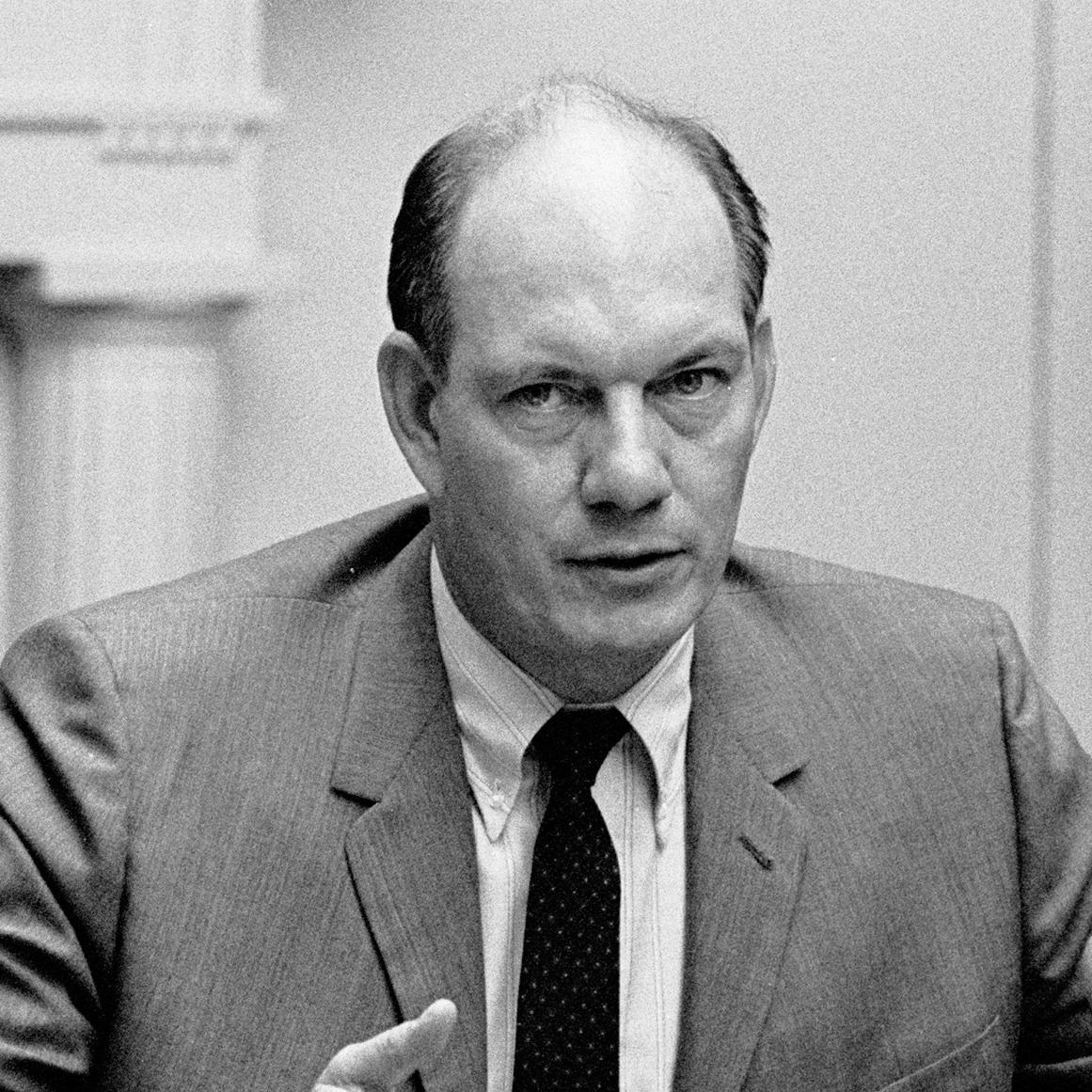 Sec. Alan S. Boyd, seated at table, speaking and gesturing with his right hand.