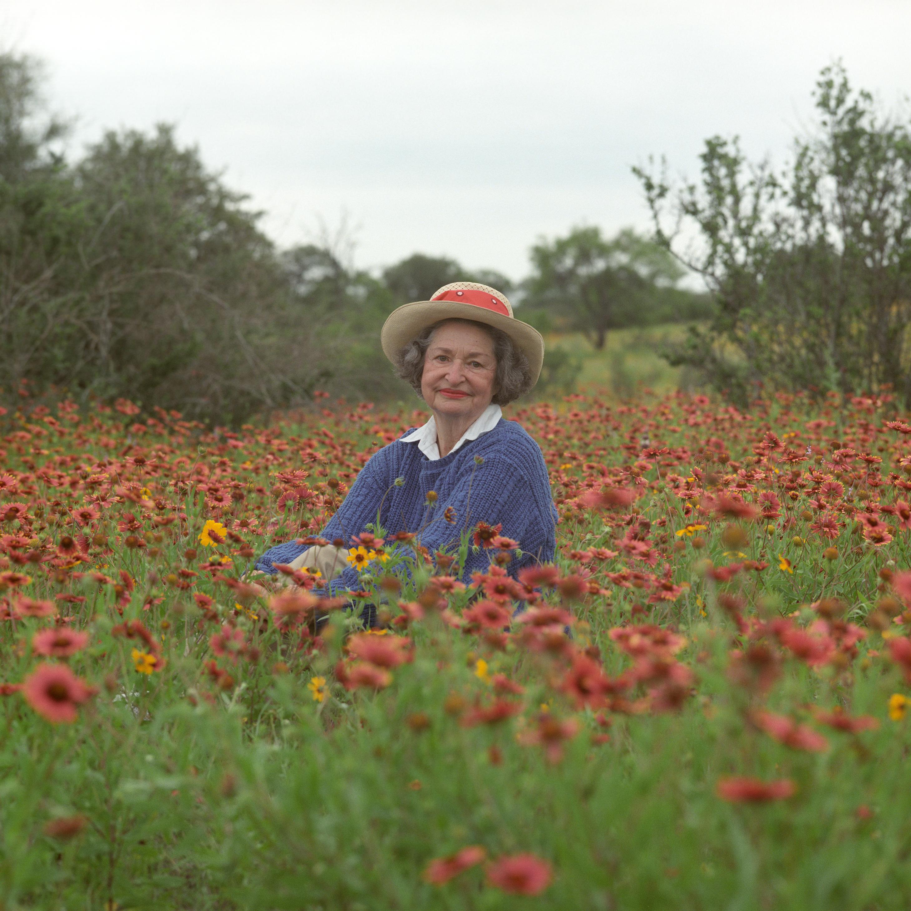 Lady Bird Johnson sits in a field of wildflowers in the Texas Hill Country.