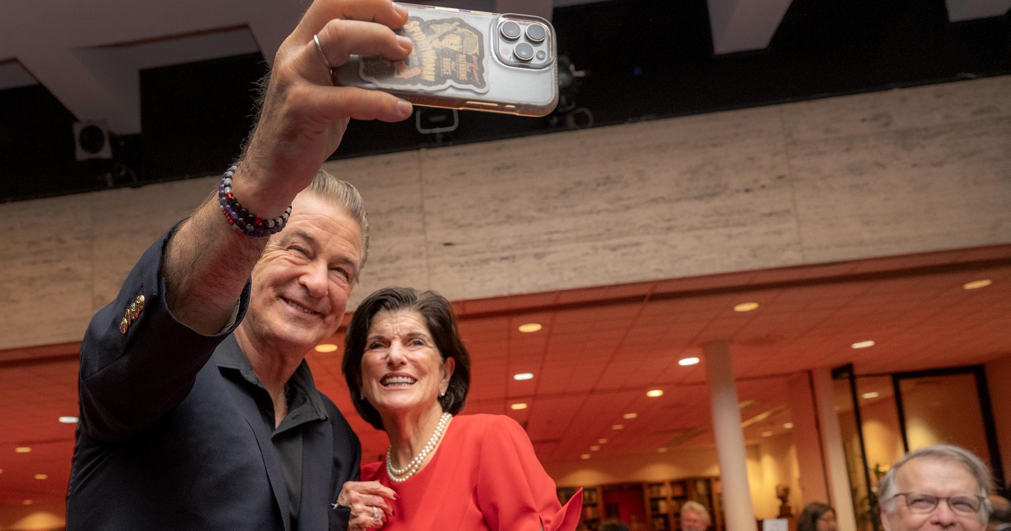 Alec Baldwin takes a photo with Luci Baines Johnson